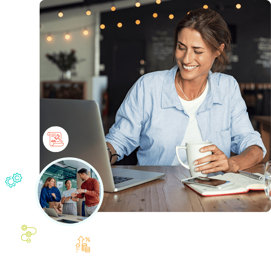 Smiling woman working on her computer sitting at a desk in a coffee shop